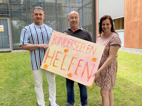 Gruppenfoto mit Schild auf dem steht "Kinderseelen helfen"