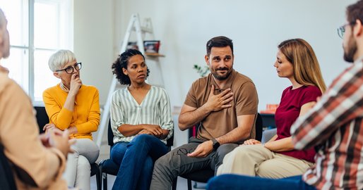 verschiedene Personen sitzen im Kreis und reden miteinander