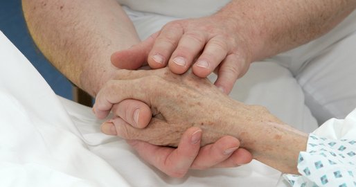 Pfleger hält Hand von Patientin