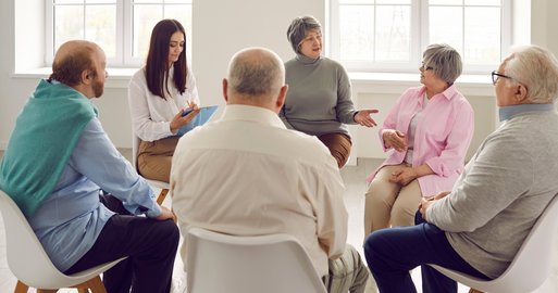 ältere Personen sitzen im Kreis und reden miteinander