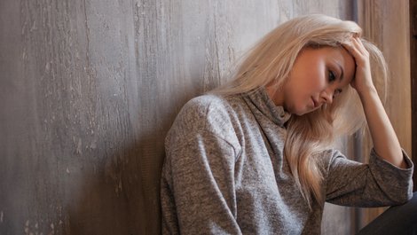 Frau hält sich depressiv den Kopf