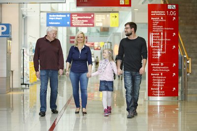 Familie geht Krankenhausgang entlang