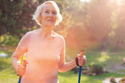 Ältere Dame beim Nordic Walking