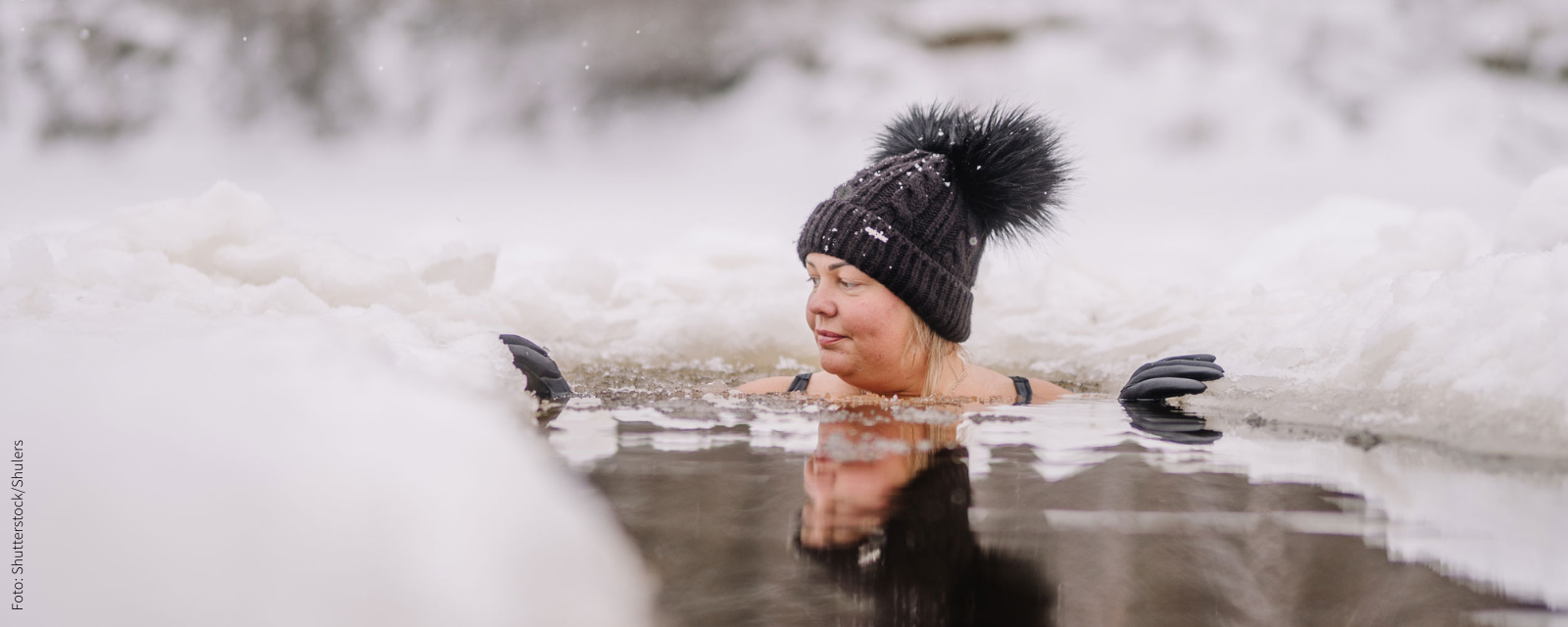 Frau beim Eisbaden mit Wollmütze